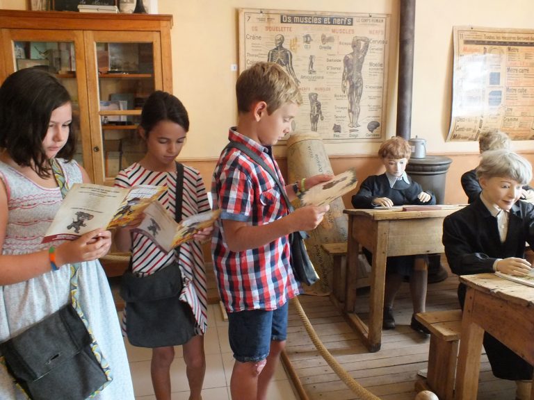 Enfants lisant le livret d'aventure avec Rosalie la petite souris au Conservatoire des Métiers d'Autrefois de Donzac